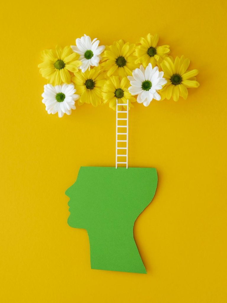 Cabeza con una escalera hacia flores representando la mentalidad de crecimiento en oposiciones